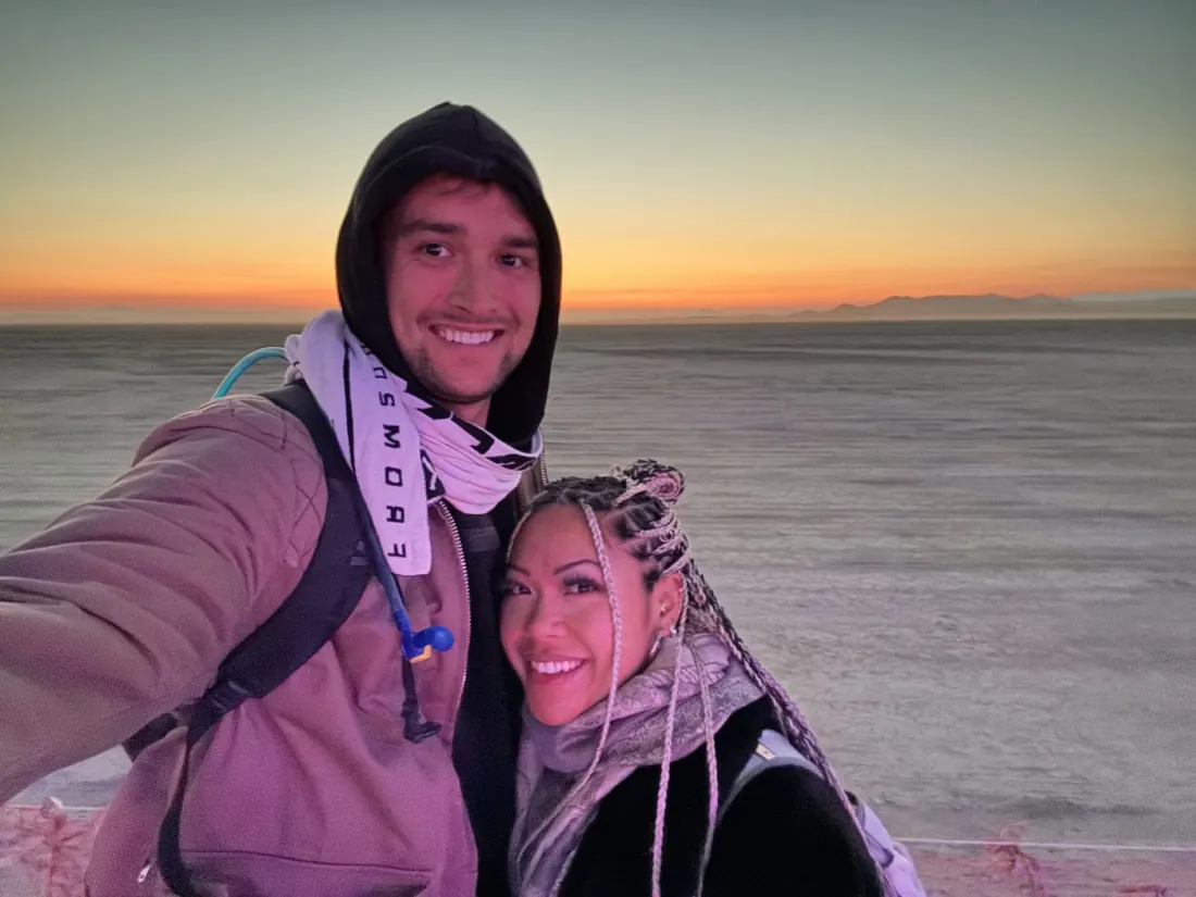 Ysabelle and Jordan bundled up at sunrise on the playa at Burning Man