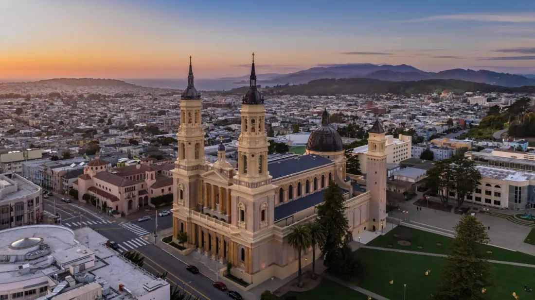 St. Ignatius Church at sunset, with the Golden Gate Bridge and Marin Headlands in the distance